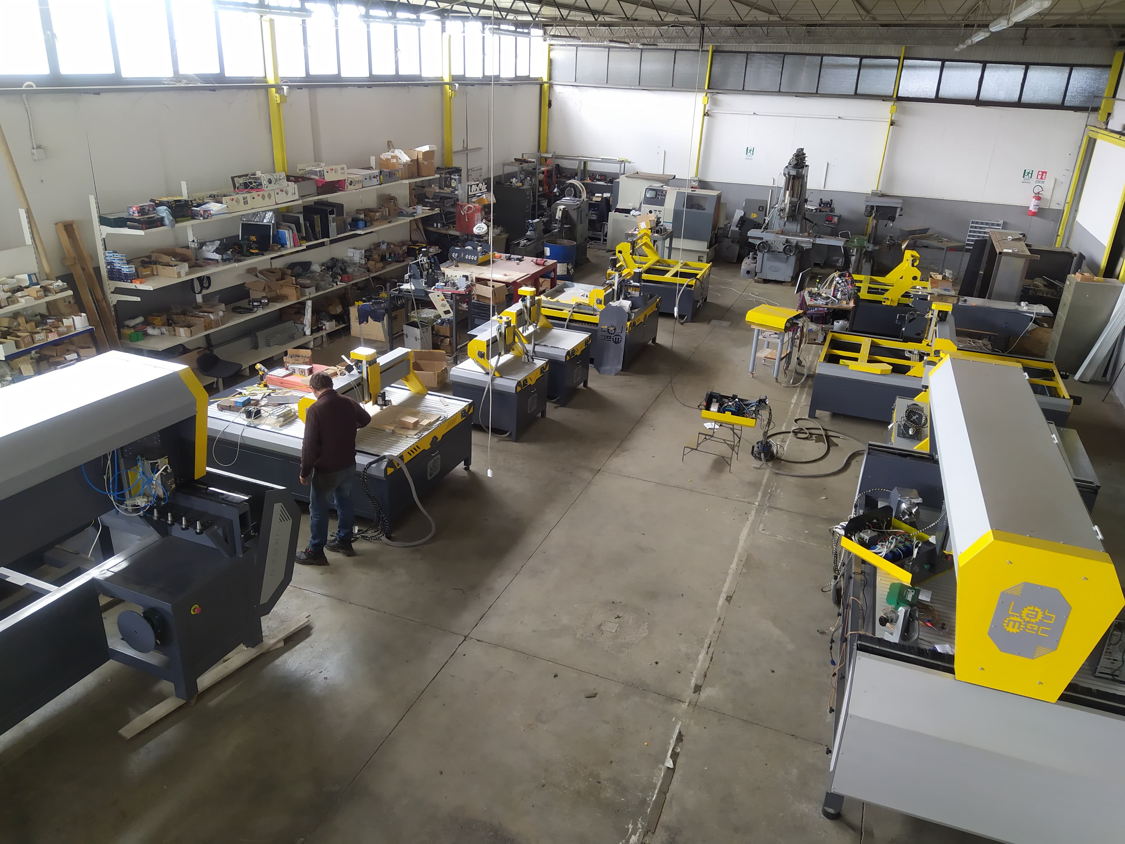 Vista interna del laboratorio LabMec con diversi pantografi CNC in fase di montaggio e collaudo tecnico, pronti per essere consegnati.